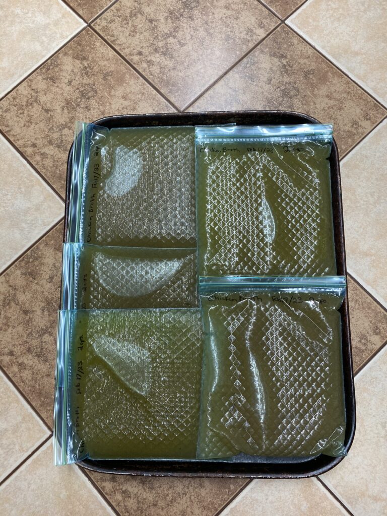 Homemade chicken broth in portioned glad freezer bags labelled